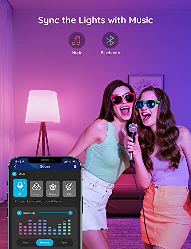 Two women singing with synced lights and a smartphone app.